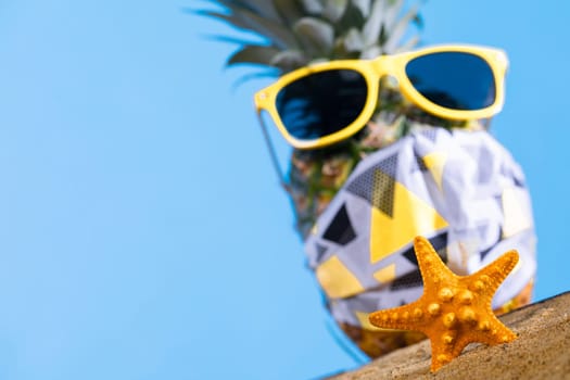 Ripe pineapple. Protective mask. Sunglasses with a yellow frame. Sea beach. Sunny day.