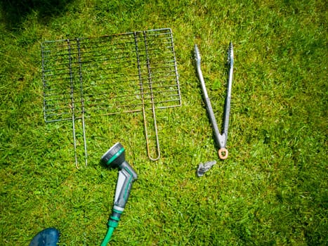 BBQ grillage rost lying on the wet lawn.