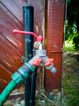 Dripping harden water tap with hose.