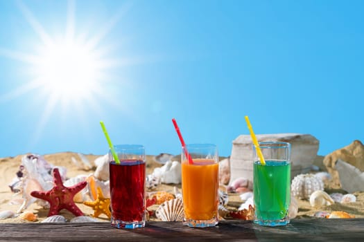 Ulane summer while on vacation. Sandy beach dotted with empty snail shells. Fresh fruit juice.