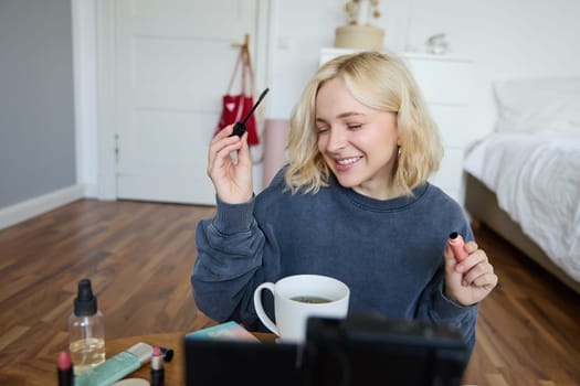 Young charismatic beauty blogger, teenage girl records video of her applying mascara, reviewing makeup products for her lifestyle vlog, vlogging for social media account.