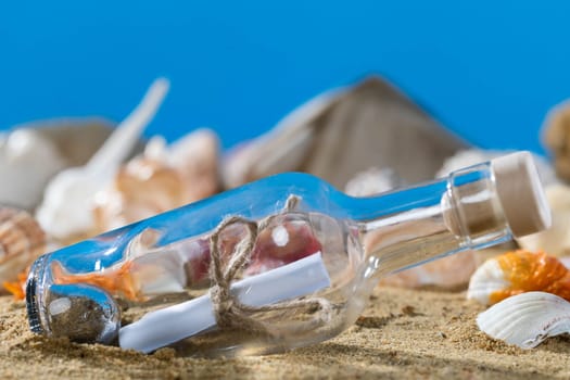 A glass bottle corked with a letter inside was on one of the sea wild beaches. Blue sky.