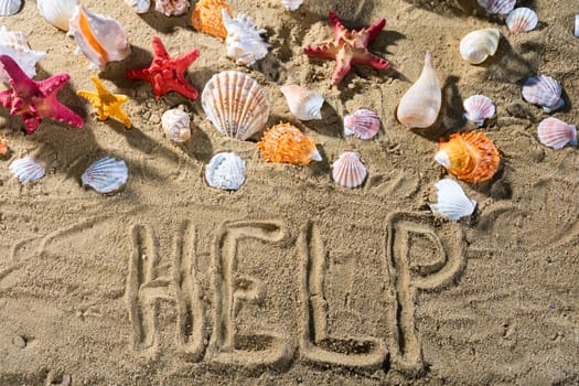 On the sand, the tourist wrote - help. Relaxing climate of a sea sandy and sunny beach.