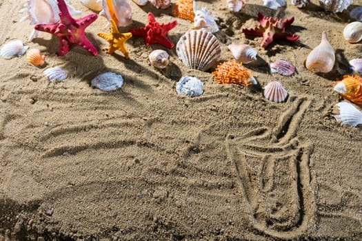 On the sand the tourist wrote a drawing - glasses with a straw. Relaxing climate of a sea sandy and sunny beach.