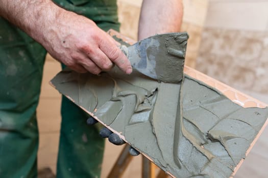 Thick cement based adhesive. A professional employee for interior finishing. Tiles - ceramic tile.