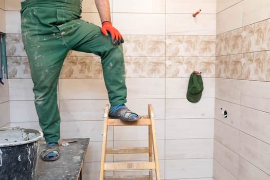 The builder took a break from work. Short rest at work standing up. Professional work footwear.