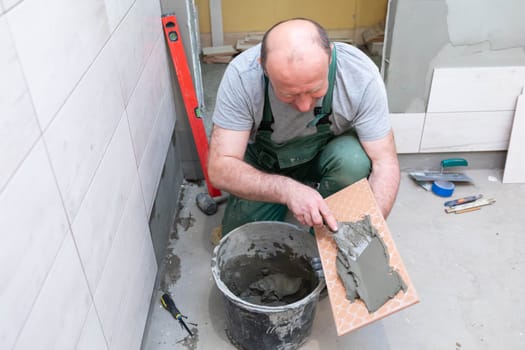 Thick cement based adhesive. A professional employee for interior finishing. Tiles - ceramic tile.