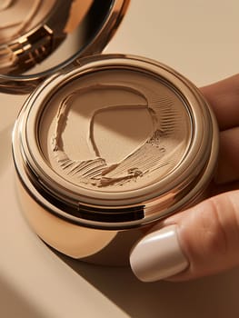 Fingers holding an artfully designed compact powder, showcasing beauty and elegance.