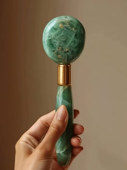 Hand holding a jade roller on facial skin, symbolizing wellness and beauty trends.