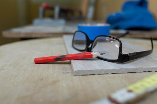 A table with the necessary tools such as a measuring cup, pencil and glasses.