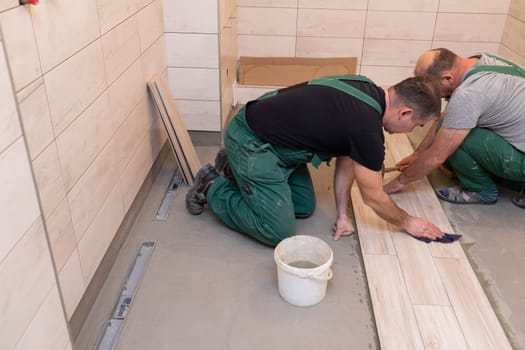 Cleaning the adhesive from ceramic tiles. Construction worker. Bathroom renovation work.