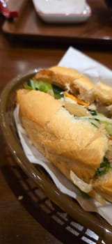 Sandwich Banh mi, vietnamese baguette with grilled chicken and mixed salad, vietnamese sandwich in local asian restaurant