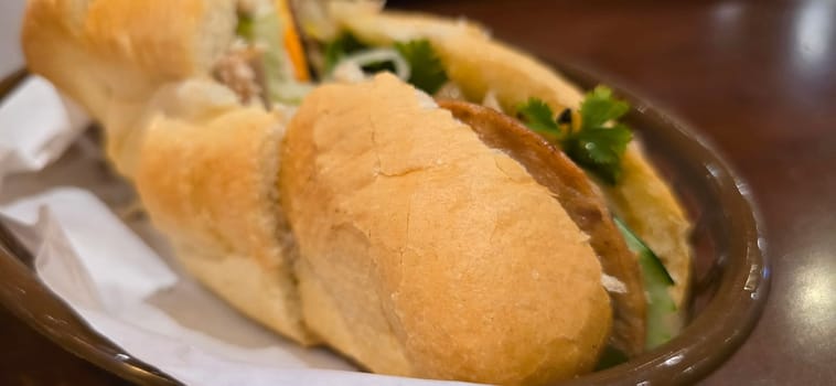 Sandwich Banh mi, vietnamese baguette with grilled chicken and mixed salad, vietnamese sandwich in local asian restaurant