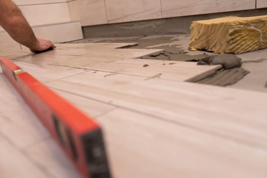 Cleaning the adhesive from ceramic tiles. Construction worker. Bathroom renovation work.