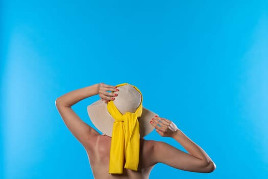 The woman's hands hold the big hat on her head.