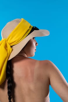 A big beach hat on his head during the hot summer against the blue sky.