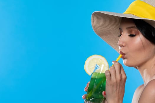 A teenager sipping a cold alcoholic drink through a straw during a hot summer.