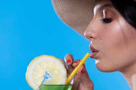 A teenager sipping a cold alcoholic drink through a straw during a hot summer.