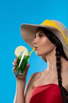 A teenager sipping a cold alcoholic drink through a straw during a hot summer.