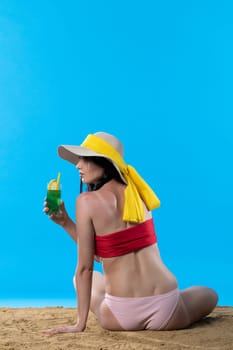 During hot summer, the teenager with a hat on her head holds an alcoholic drink in her hand.