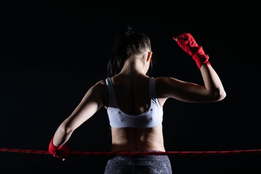 The fighter won her first fight. The woman raised her hands in evidence of winning the fight.