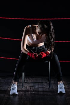 A lost fight of a strong player. He is sitting in a chair. Right after losing the fight. Sad woman after a fight in the ring.