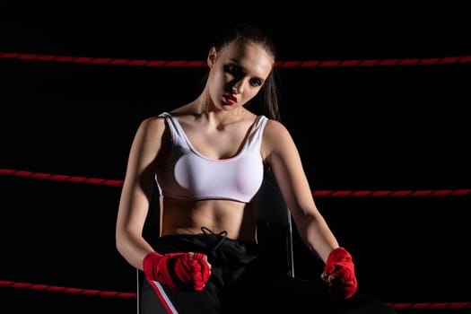 A lost fight of a strong player. He is sitting in a chair. Right after losing the fight. Sad woman after a fight in the ring.