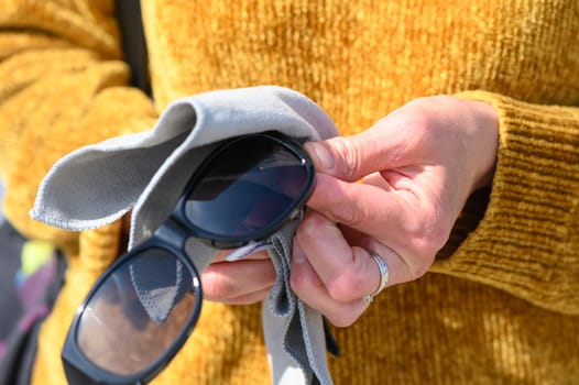 female hands wiping sunglasses with a napkin 5