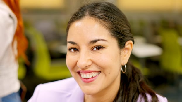 A smiling woman looking at camera sitting in a coworking