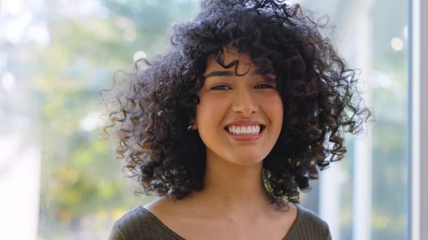 Beauty african woman with curly hair smiling at camera at home