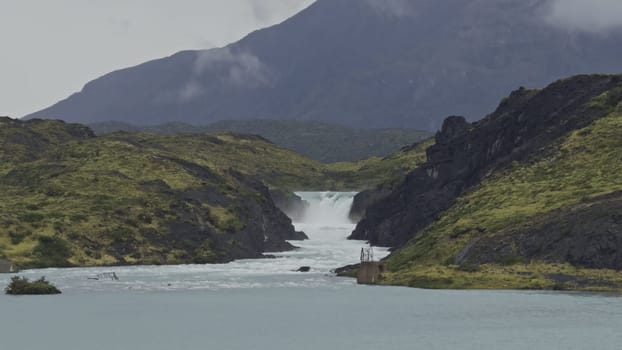 Slow-motion footage captures a majestic waterfall in Torres del Paine cascading into a vivid lake.