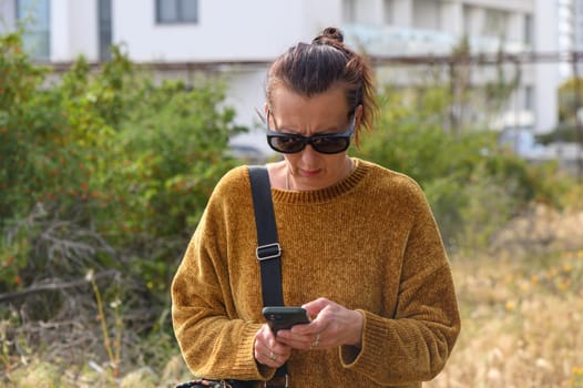 Woman with mobile next to buildings