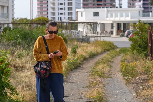 Woman with mobile next to buildings 1