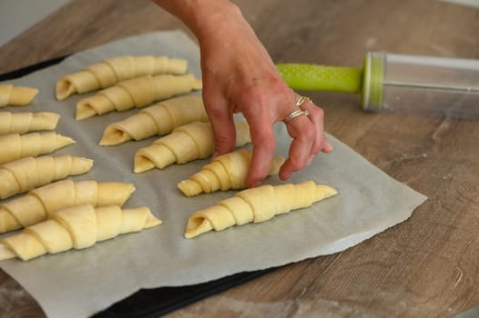 Male Baker Correcting Croissant Shaped Pastries In Modern Bakery