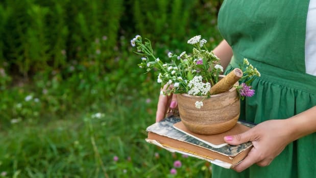 A woman collects medicinal herbs and makes herbal tincture