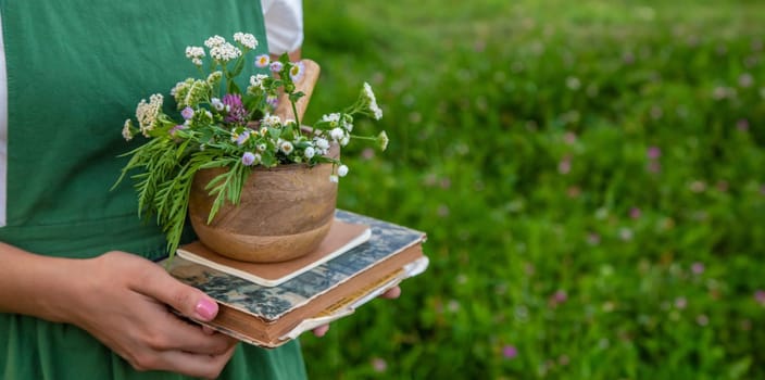 A woman collects medicinal herbs and makes herbal tincture