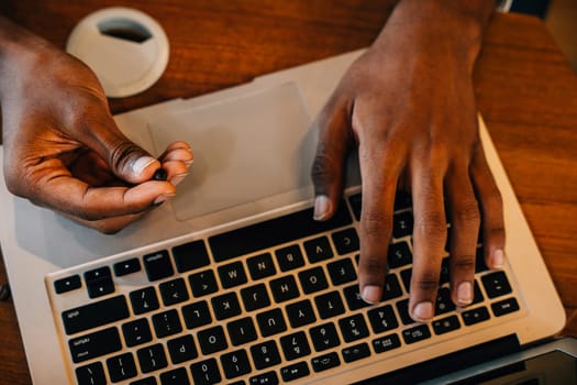 At the coffee roastery the owner a barista uses technology to check bean quality on laptop and machinery. Precision in checking ensures top-notch beans. Business owner scrutiny gives confidence.