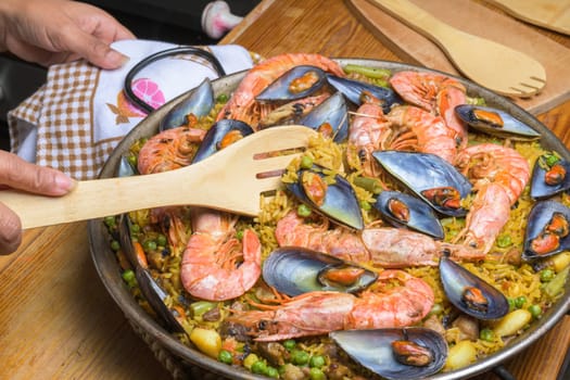 Traditional seafood paella with prawns and mussels in a pan, served with a wooden spoon, typical Spanish cuisine, Majorca, Balearic Islands, Spain,