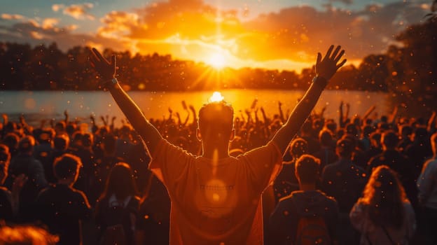 A man with his arms up in the air at sunset