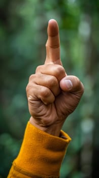A person pointing at something with their finger in a yellow shirt