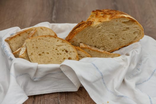 Close up of a loaf of homemade sourdough bread in a bread bininterior background 1