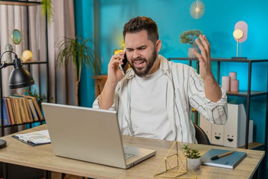 Quarrel. Furious annoyed businessman freelancer engage in heated phone conversations at home office. Upset boss expresses frustration using cellphone manager guy disputes with subordinates. Lifestyle