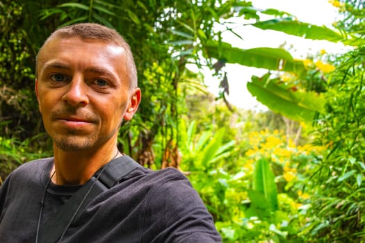 Handsome male tourist man at tropical jungle and forest hiking trails through nature to the mountain peak in Chiang Mai Amphoe Mueang Chiang Mai Thailand in Southeastasia Asia.