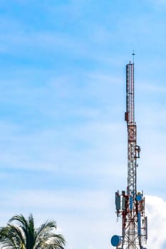 Red white 5G tower with blue sky background radiation kills us in Zicatela Puerto Escondido Oaxaca Mexico.