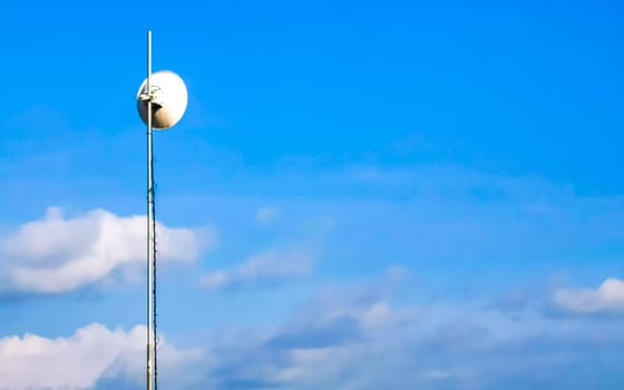 Red white 5G tower with blue sky background radiation kills us in Zicatela Puerto Escondido Oaxaca Mexico.