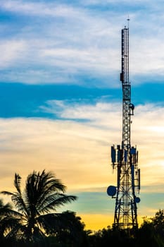 Red white 5G tower with blue sky background radiation kills us with sunset palm tree sky background in Zicatela Puerto Escondido Oaxaca Mexico.