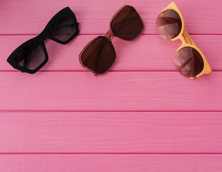 Summer abstract background mockup template free copy space for text pattern sample top view above on pink wooden board. blank empty area for inscription. Couple Stylish black sunglasses fashionable