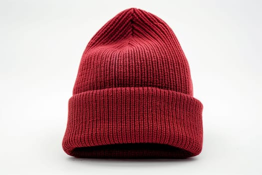 A red knitted hat is displayed on a plain white background, showcasing its texture and vibrant color.