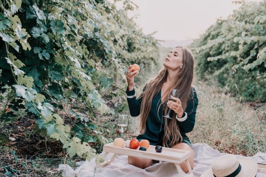 Picnic and wine tasting at sunset in the hills of Italy, Tuscany. Vineyards and open nature in the summer. Romantic dinner, fruit and wine.