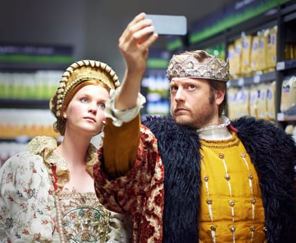 Selfie, supermarket and king and queen in costume for social media, online post and internet memories. Medieval fashion, renaissance and people take picture in market, store and shop in royal outfit.